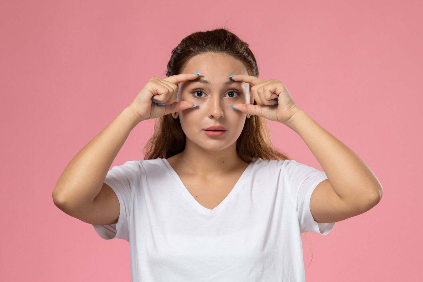 front-view-young-attractive-female-white-t-shirt-posing-showing-her-eyes-pink-background_140725-26209